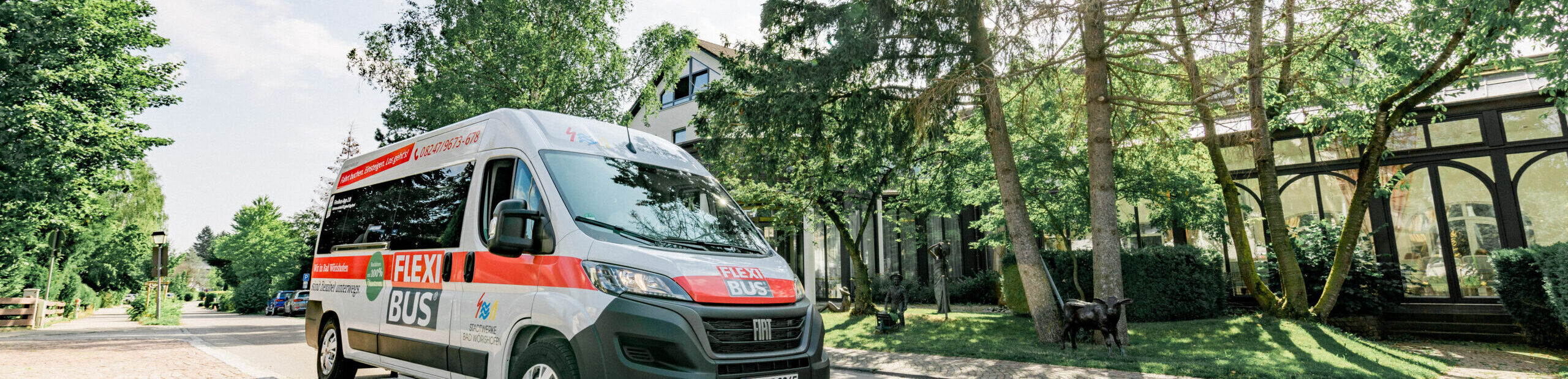 Der Flexibus auf der Straße und Bäume im Hintergrund.