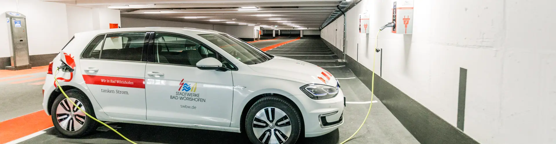 Elektroauto beim Ladevorgang im Parkhaus