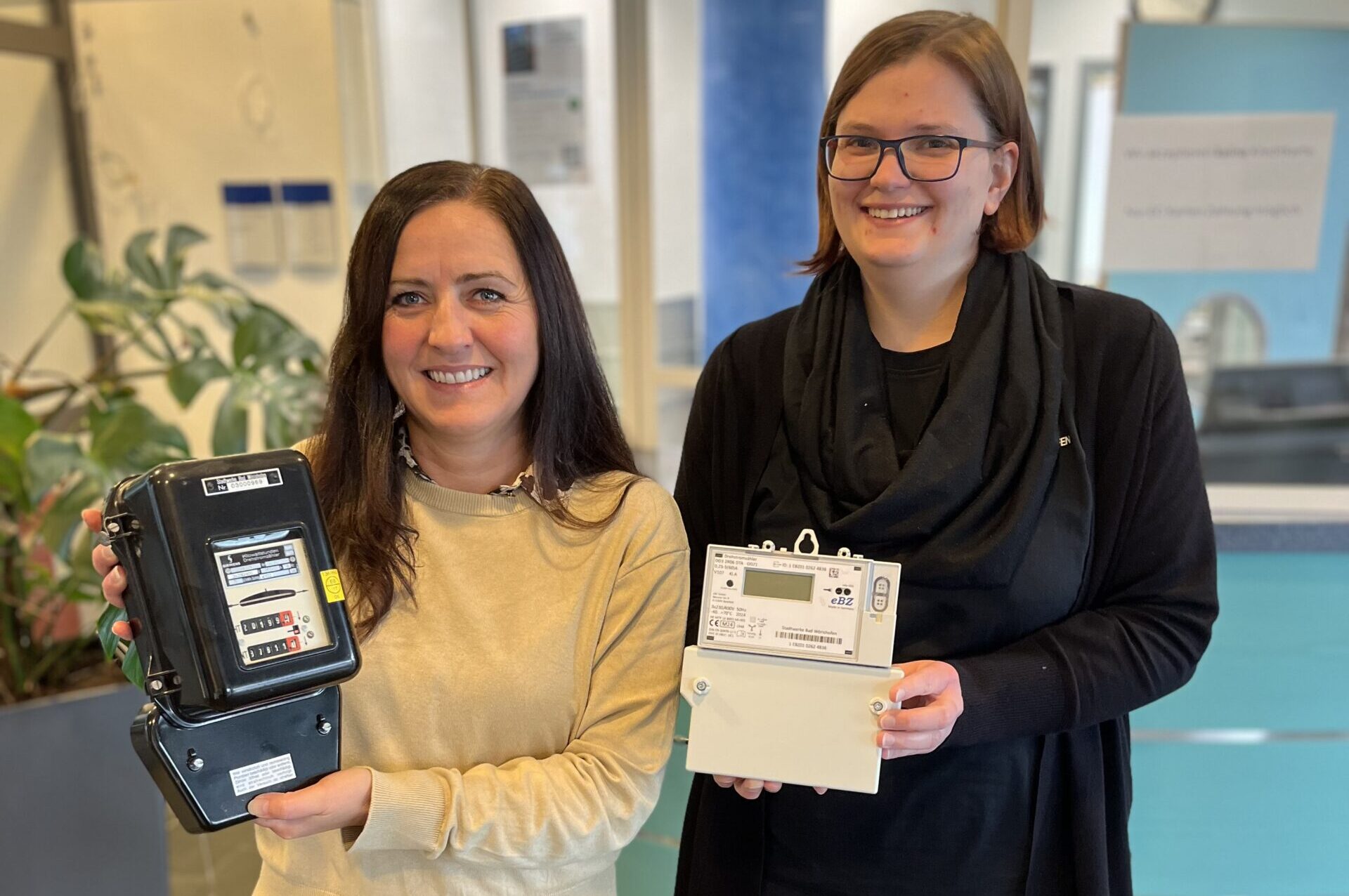 Zwei Frauen stehen mit Stromzählern in der Hand im Kundenservice der Stadtwerke.