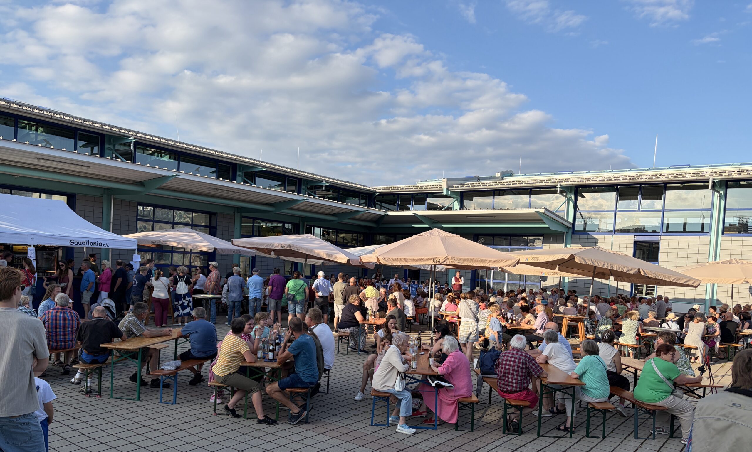 Open-Air-Konzert der Stadtkapelle im Innenhof der Stadtwerke. Gäste, Sonnenschirme an einem lauen Sommerabend.
